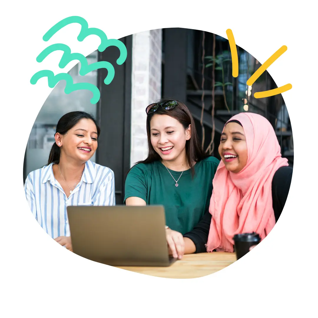 A group of women gathered around a laptop.